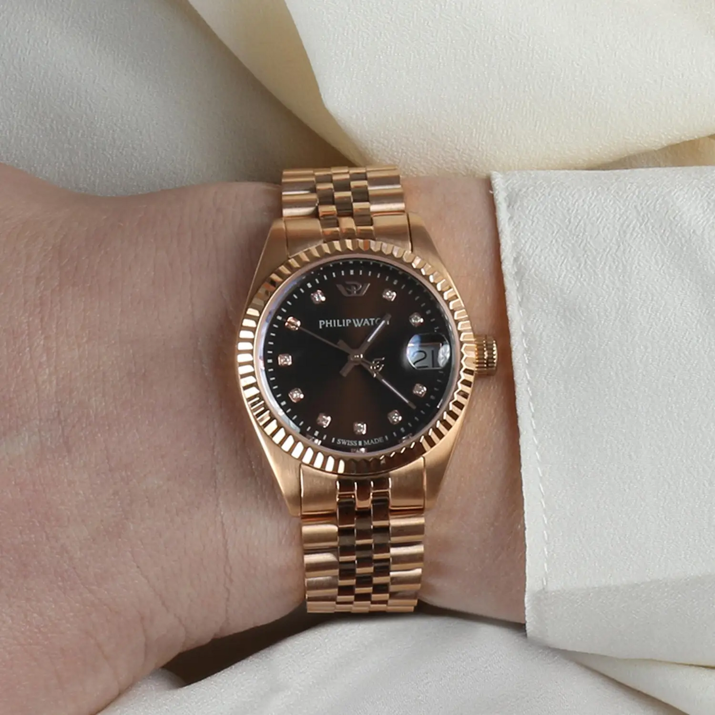 Orologio donna Philip Watch R8253597520 collezione Caribe, cassa rotonda da 31 mm in acciaio oro rosa, quadrante marrone con indici in diamanti e datario a lente, vetro zaffiro antiriflesso, bracciale in acciaio oro rosa, movimento al quarzo Swiss Made.